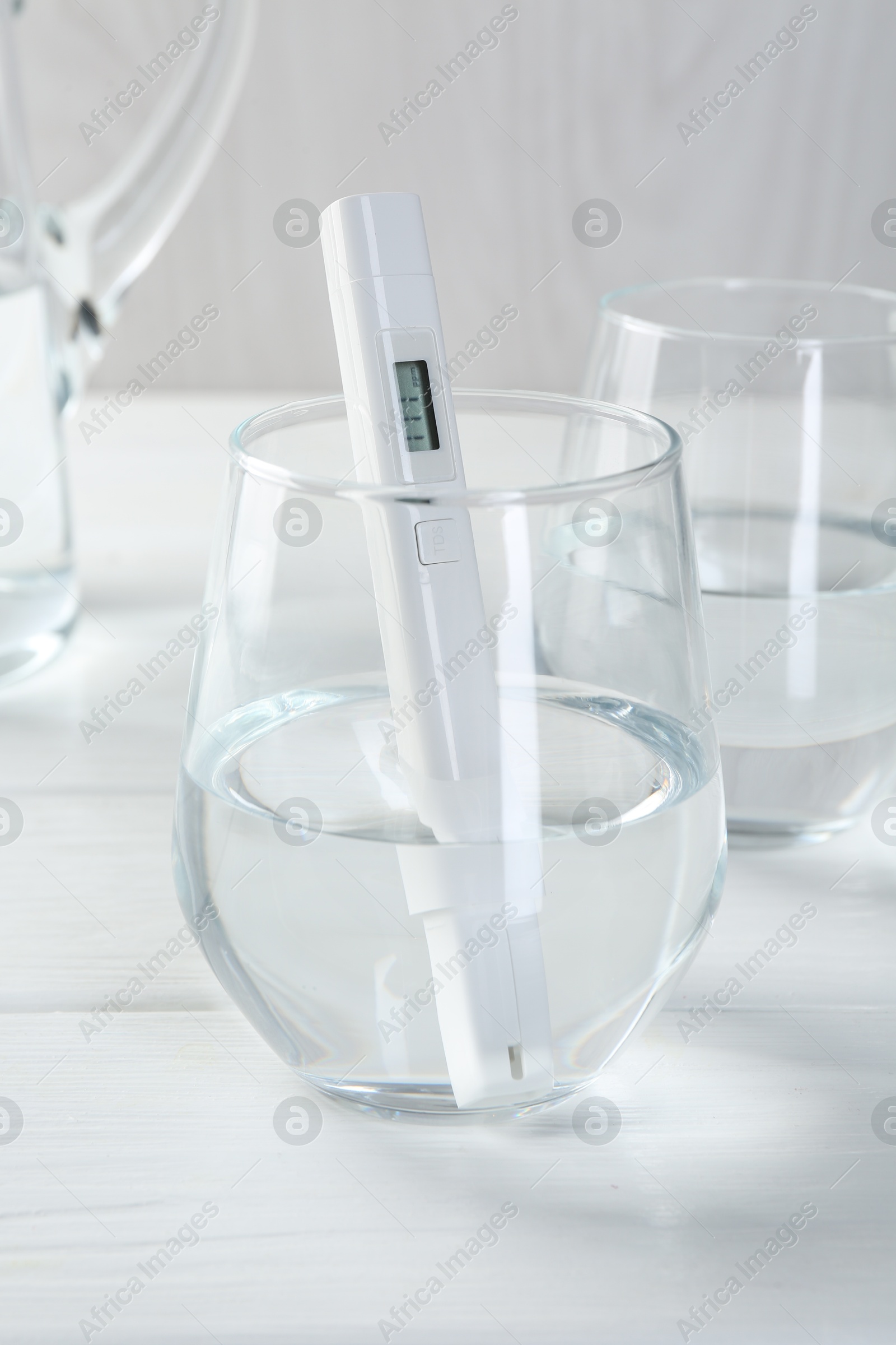 Nitrate tester in glass of water on white wooden table, closeup Photo of Nitrate tester in glass of water on white wooden table, closeup