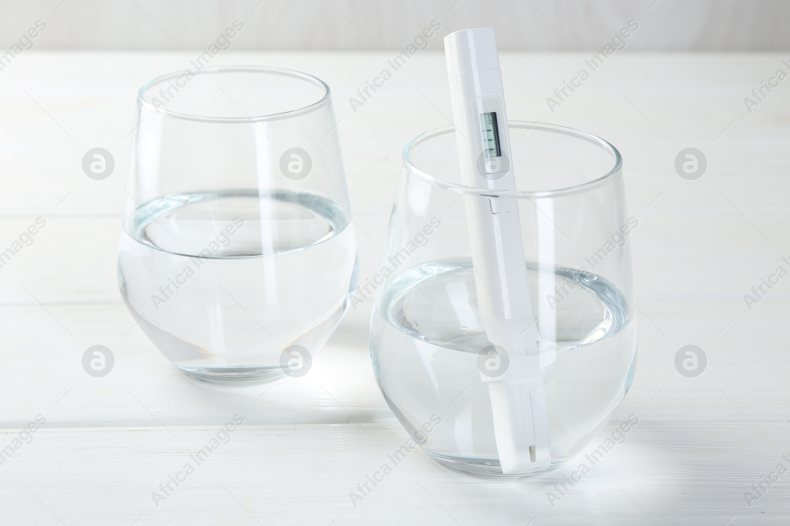 Nitrate tester in glass of water on white wooden table, closeup Photo of Nitrate tester in glass of water on white wooden table, closeup