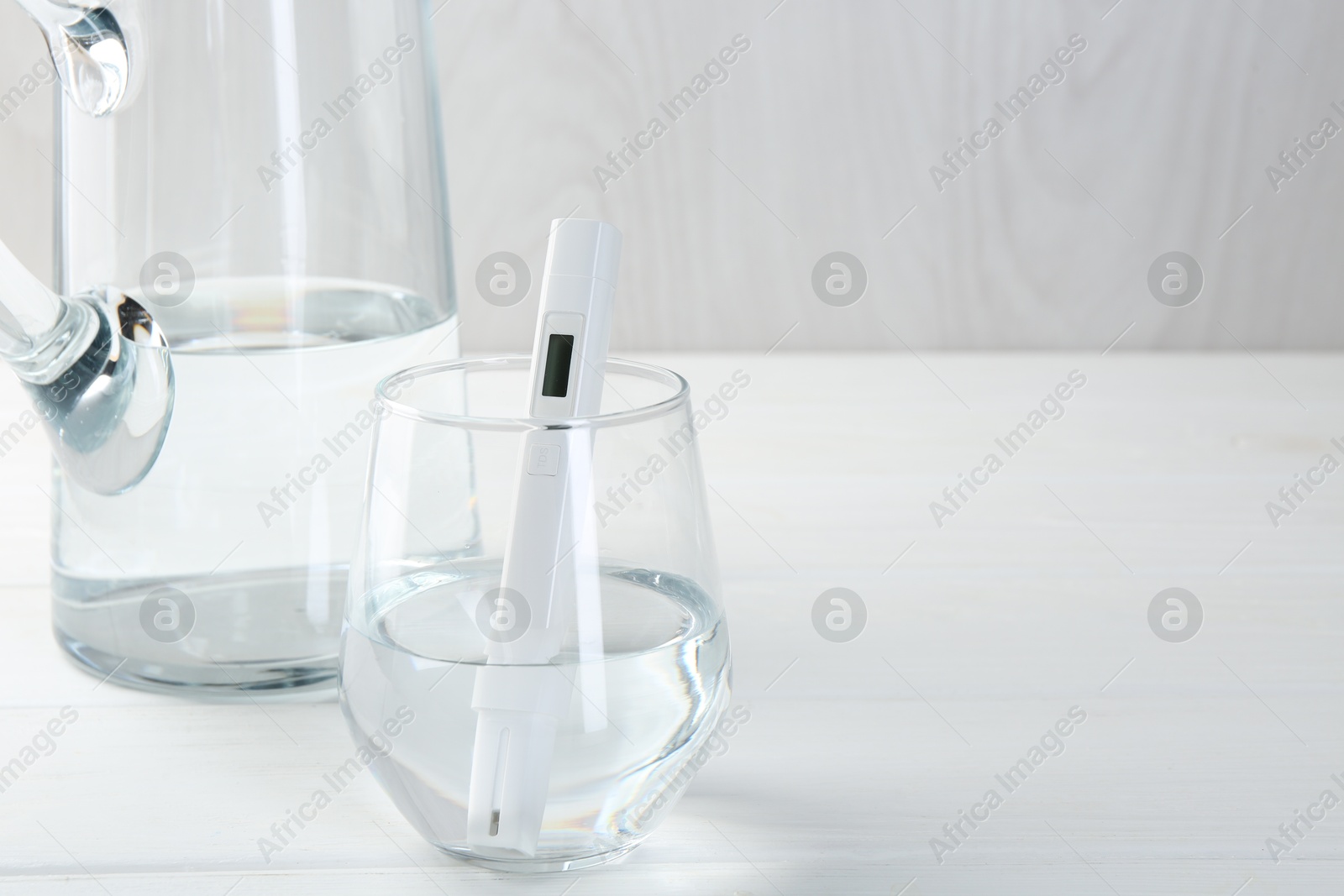 Nitrate tester in glass of water on white wooden table, closeup. Space for text Photo of Nitrate tester in glass of water on white wooden table, closeup. Space for text