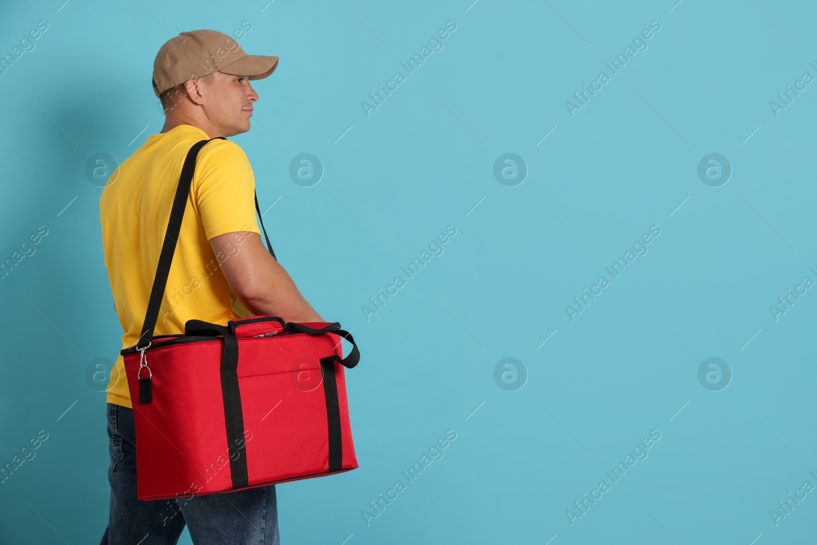 Courier with thermo bag on light blue background, space for text. Food delivery service Photo of Courier with thermo bag on light blue background, space for text. Food delivery service
