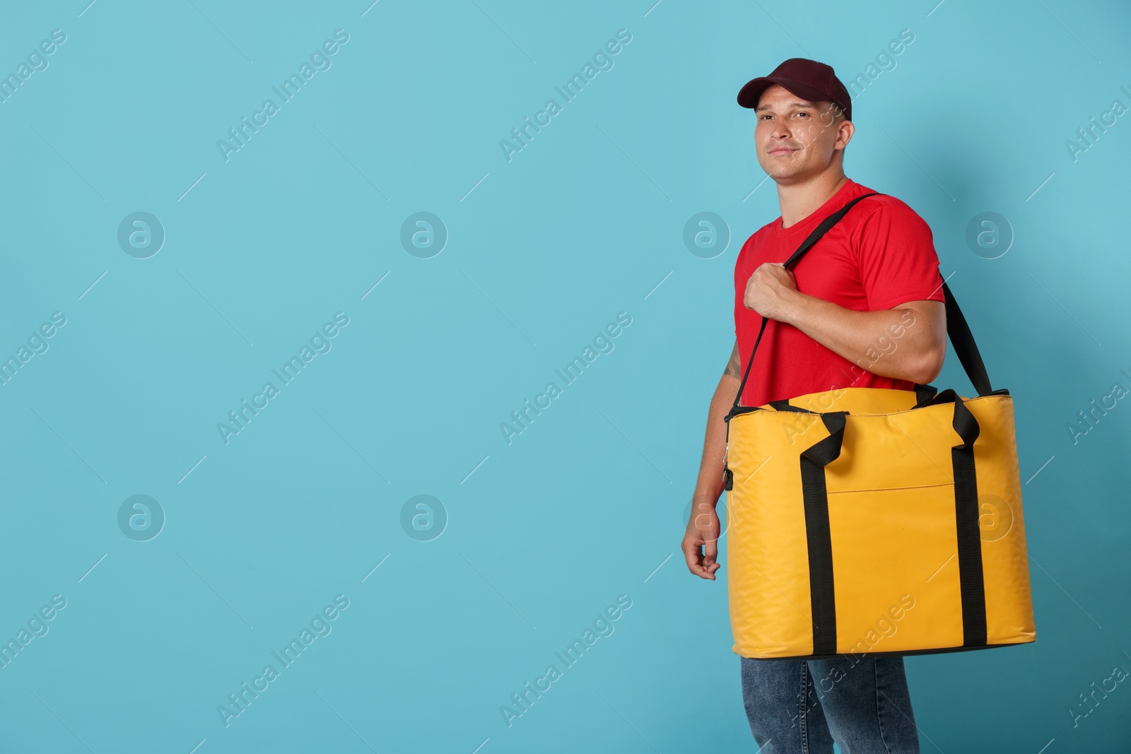 Courier with thermo bag on light blue background, space for text. Food delivery service Photo of Courier with thermo bag on light blue background, space for text. Food delivery service