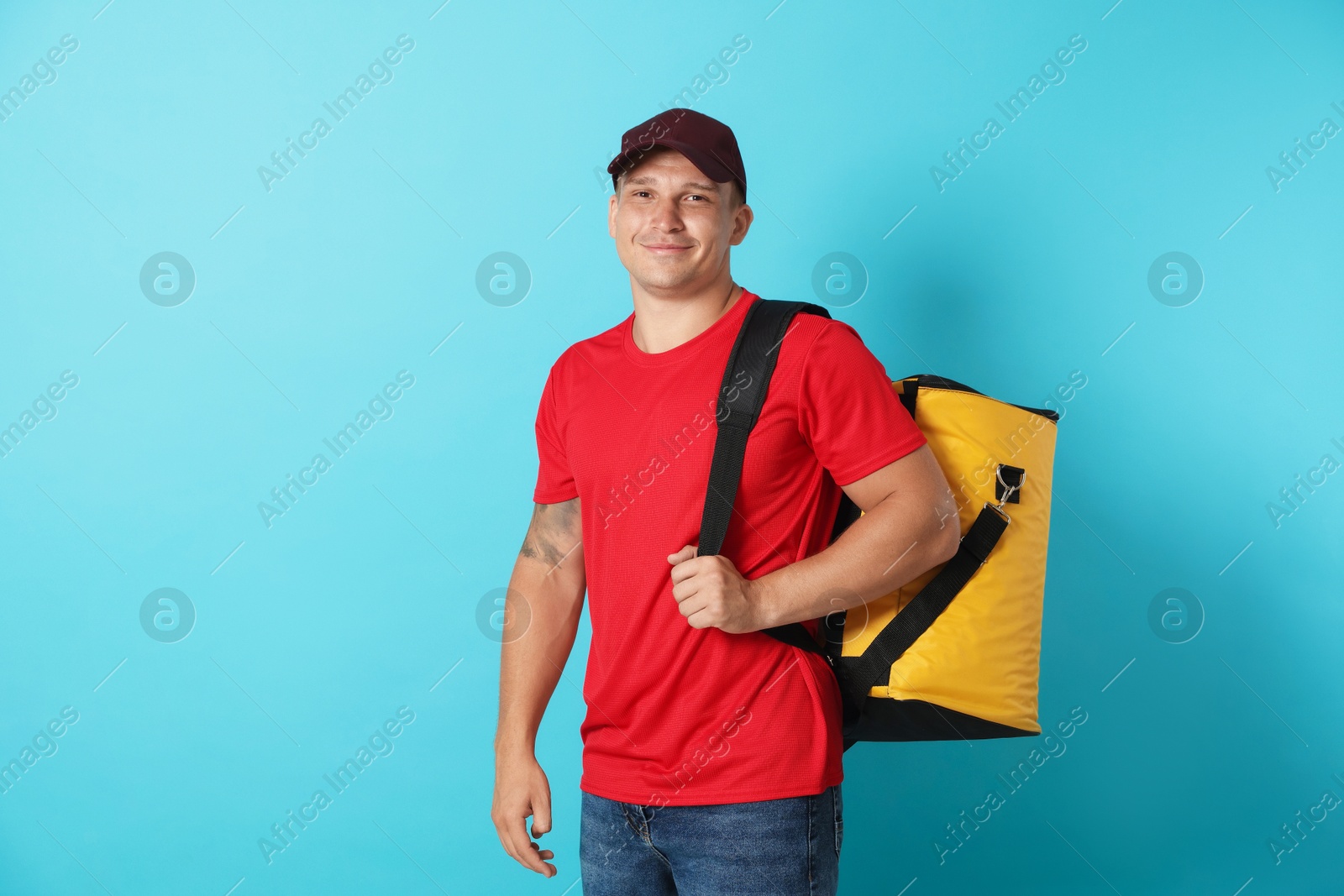 Courier with thermo bag on light blue background. Food delivery service Photo of Courier with thermo bag on light blue background. Food delivery service