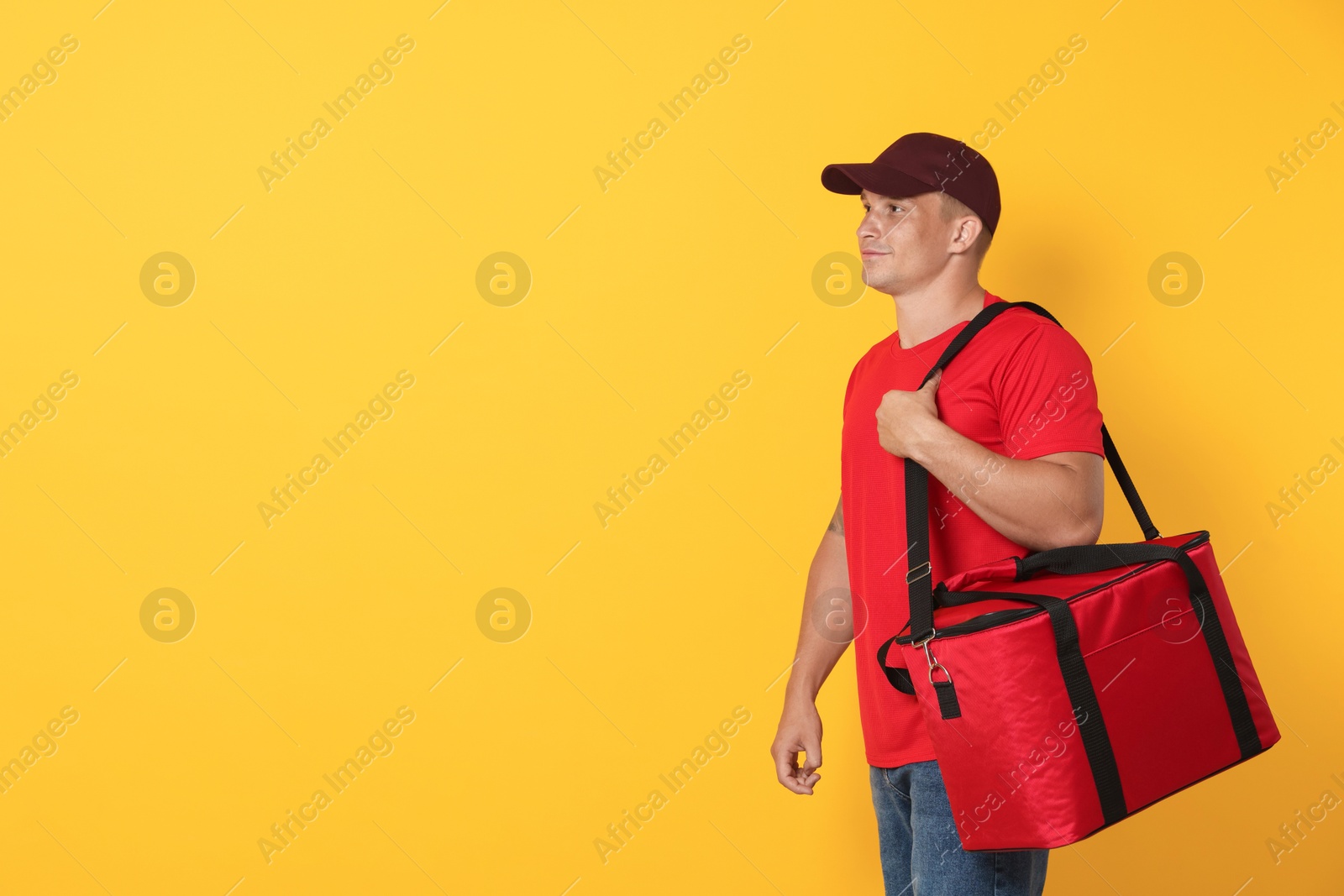 Courier with thermo bag on orange background, space for text. Food delivery service Photo of Courier with thermo bag on orange background, space for text. Food delivery service