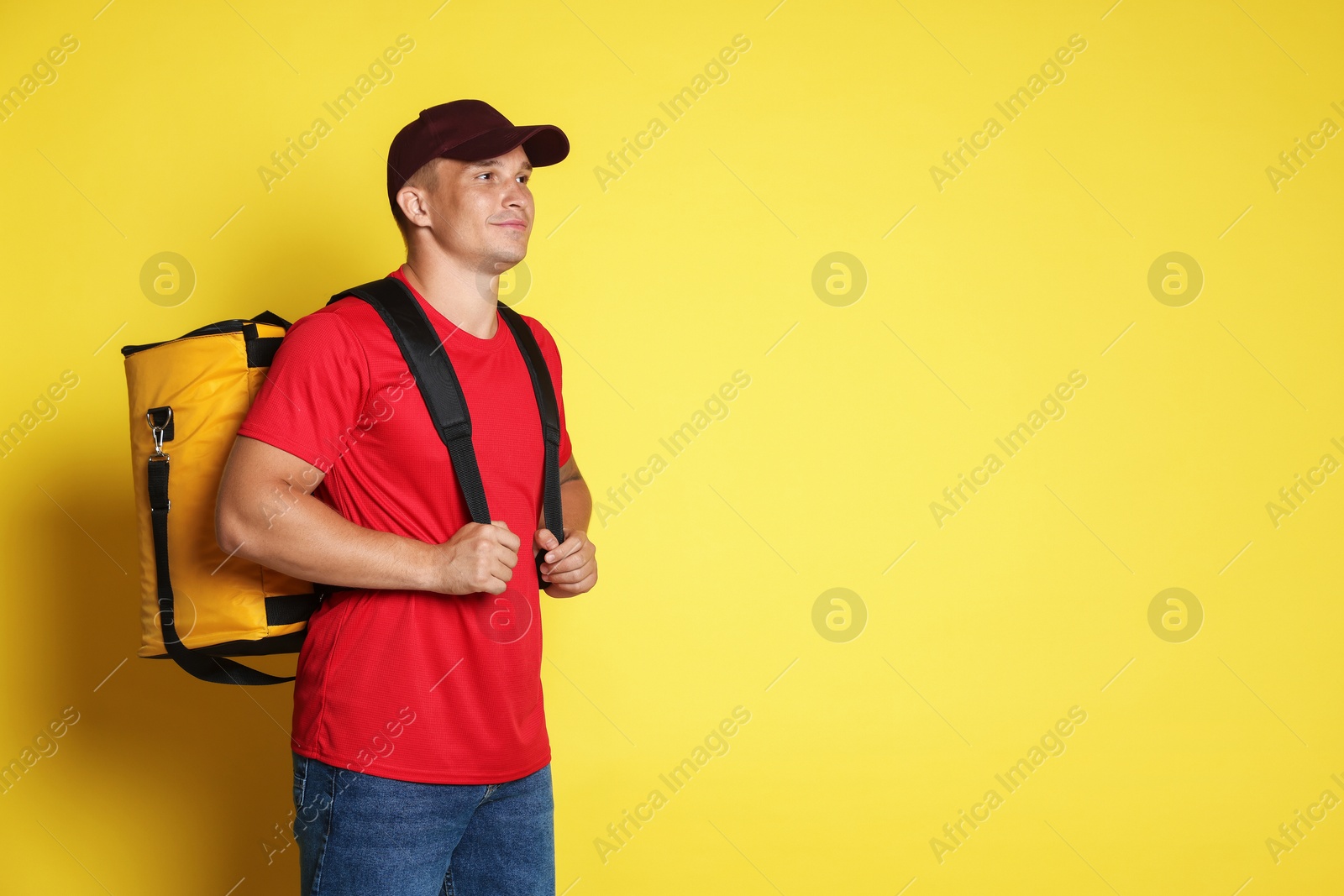 Courier with thermo bag on yellow background, space for text. Food delivery service Photo of Courier with thermo bag on yellow background, space for text. Food delivery service