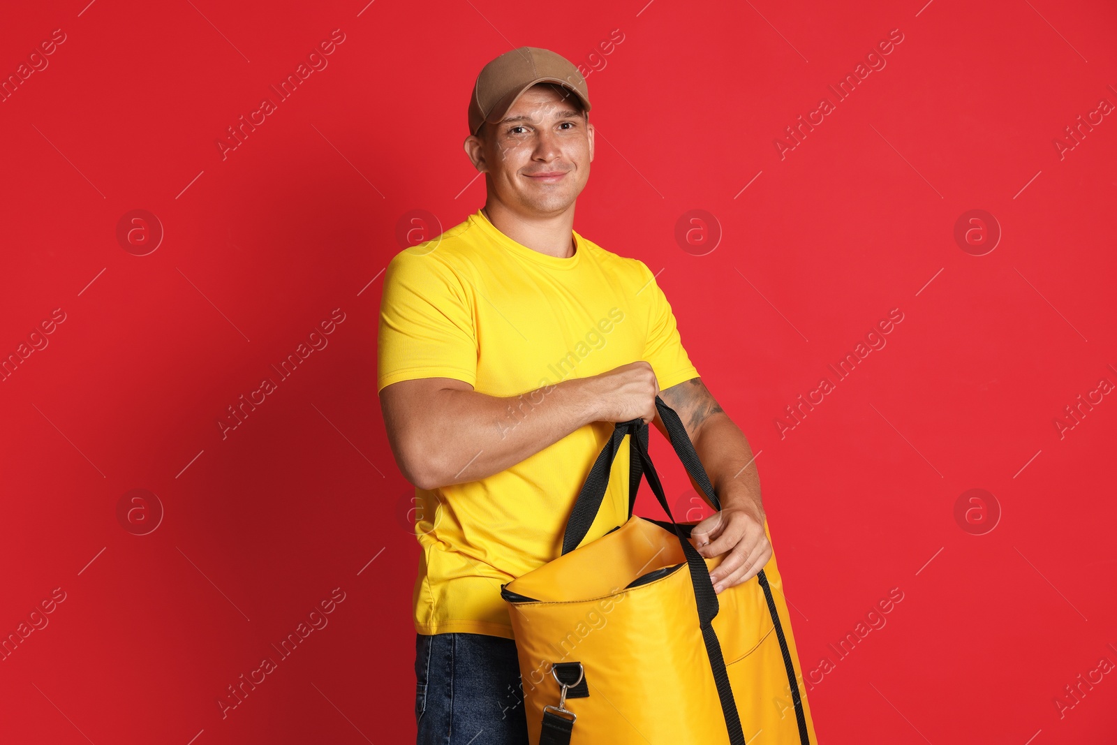Courier with thermo bag on red background. Food delivery service Photo of Courier with thermo bag on red background. Food delivery service