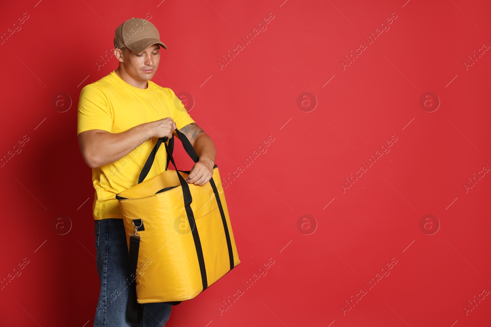 Courier with thermo bag on red background, space for text. Food delivery service Photo of Courier with thermo bag on red background, space for text. Food delivery service