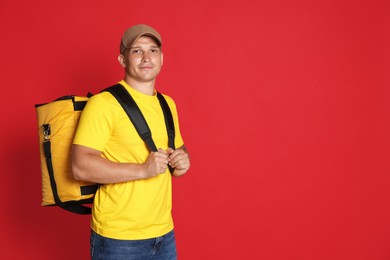 Photo of Courier with thermo bag on red background, space for text. Food delivery service