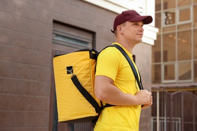Photo of Courier with thermo bag on city street. Food delivery service