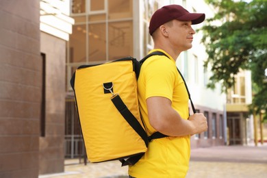 Photo of Courier with thermo bag on city street. Food delivery service