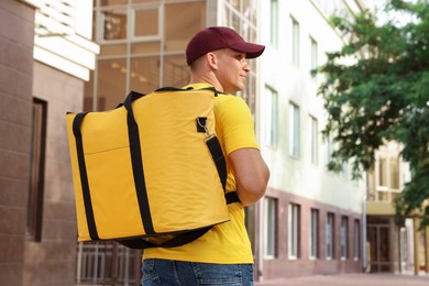 Photo of Courier with thermo bag on city street. Food delivery service