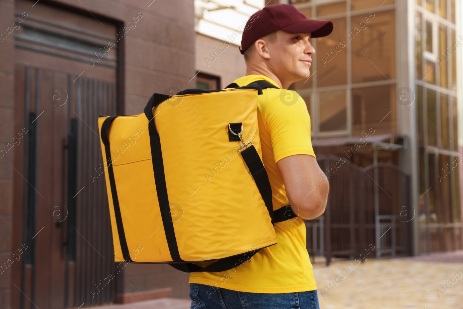 Courier with thermo bag on city street. Food delivery service Photo of Courier with thermo bag on city street. Food delivery service