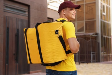 Photo of Courier with thermo bag on city street. Food delivery service