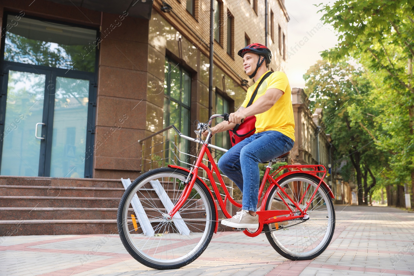 Courier with thermo bag riding bicycle outdoors, low angle view. Food delivery service Photo of Courier with thermo bag riding bicycle outdoors, low angle view. Food delivery service