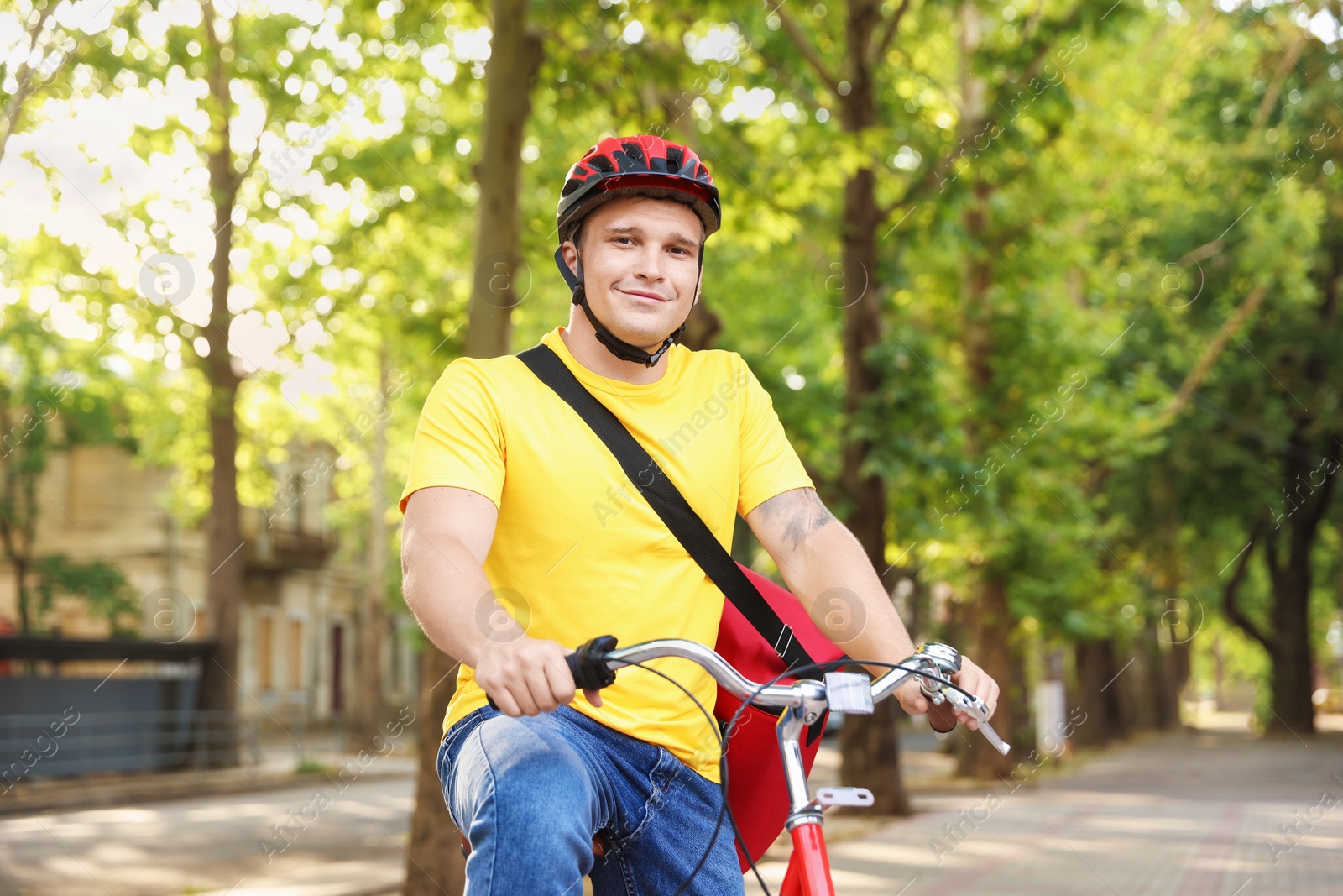 Courier with thermo bag riding bicycle outdoors. Food delivery service Photo of Courier with thermo bag riding bicycle outdoors. Food delivery service