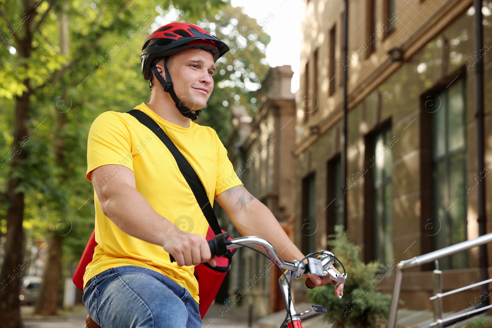 Courier with thermo bag riding bicycle outdoors, low angle view. Food delivery service Photo of Courier with thermo bag riding bicycle outdoors, low angle view. Food delivery service
