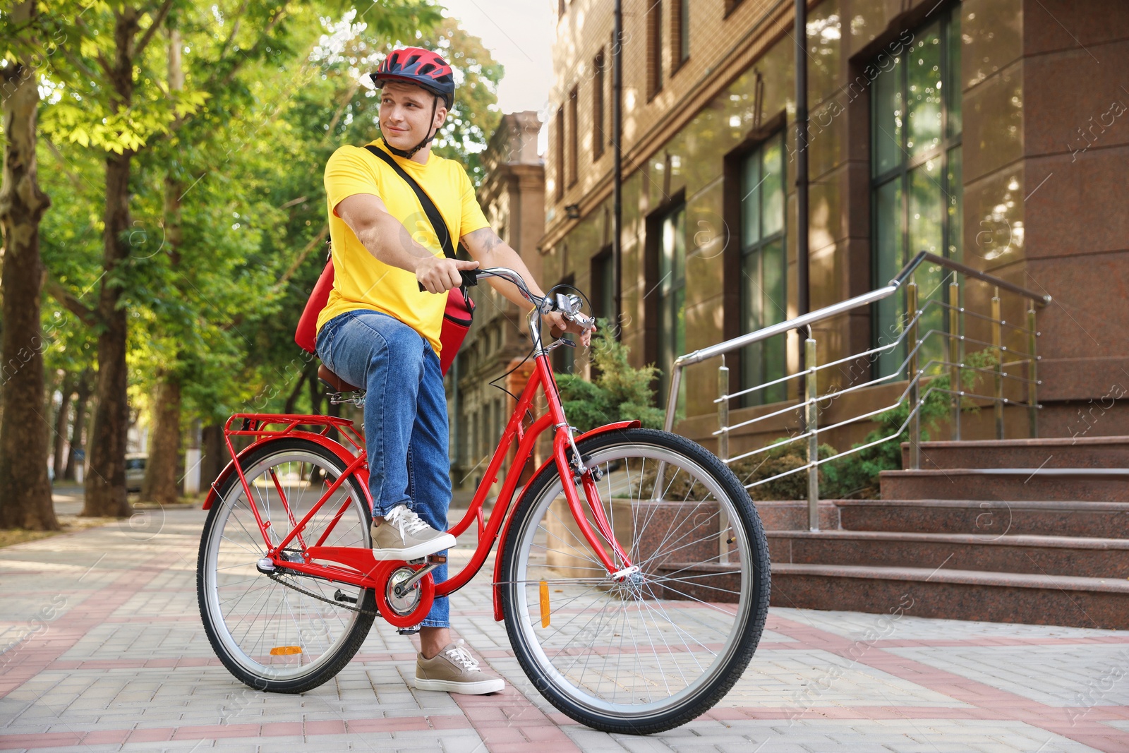 Courier with thermo bag on bicycle outdoors. Food delivery service Photo of Courier with thermo bag on bicycle outdoors. Food delivery service