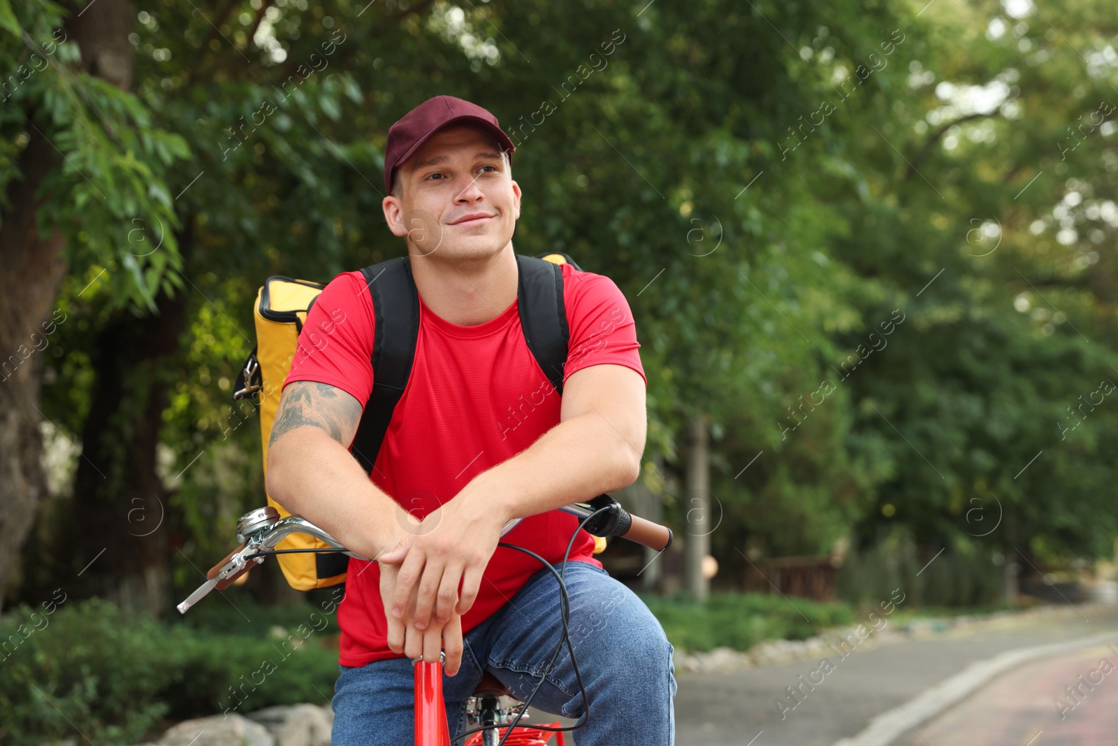 Photo of Courier with thermo bag on bicycle outdoors, space for text. Food delivery service