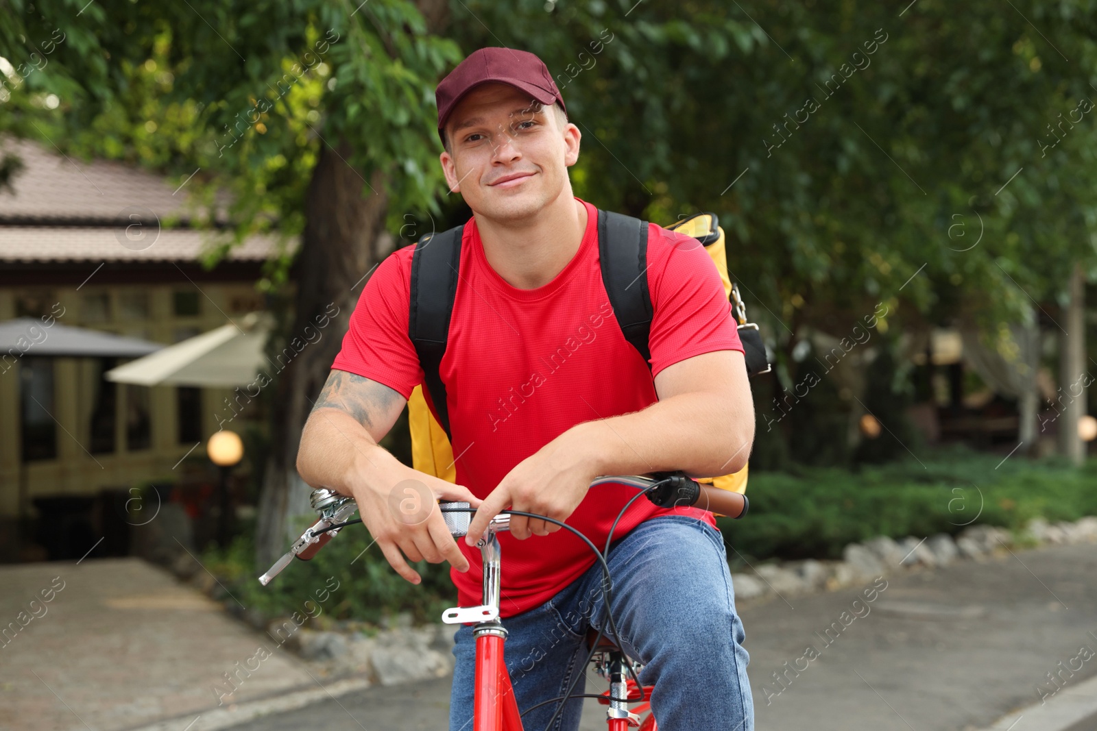 Courier with thermo bag on bicycle outdoors. Food delivery service Photo of Courier with thermo bag on bicycle outdoors. Food delivery service