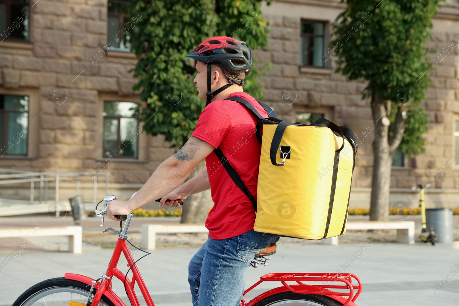 Courier with thermo bag riding bicycle outdoors. Food delivery service Photo of Courier with thermo bag riding bicycle outdoors. Food delivery service