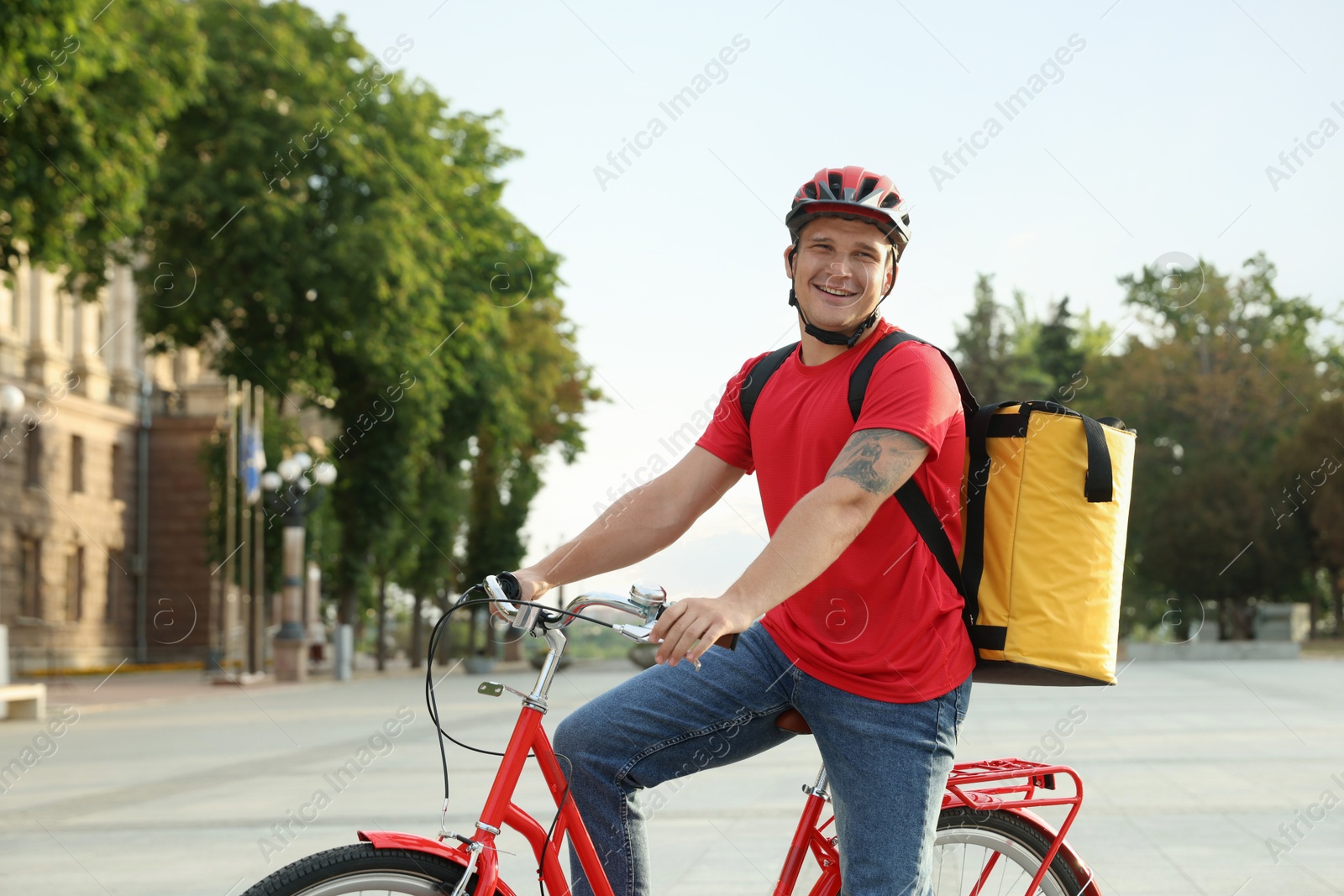 Courier with thermo bag on bicycle outdoors. Food delivery service Photo of Courier with thermo bag on bicycle outdoors. Food delivery service