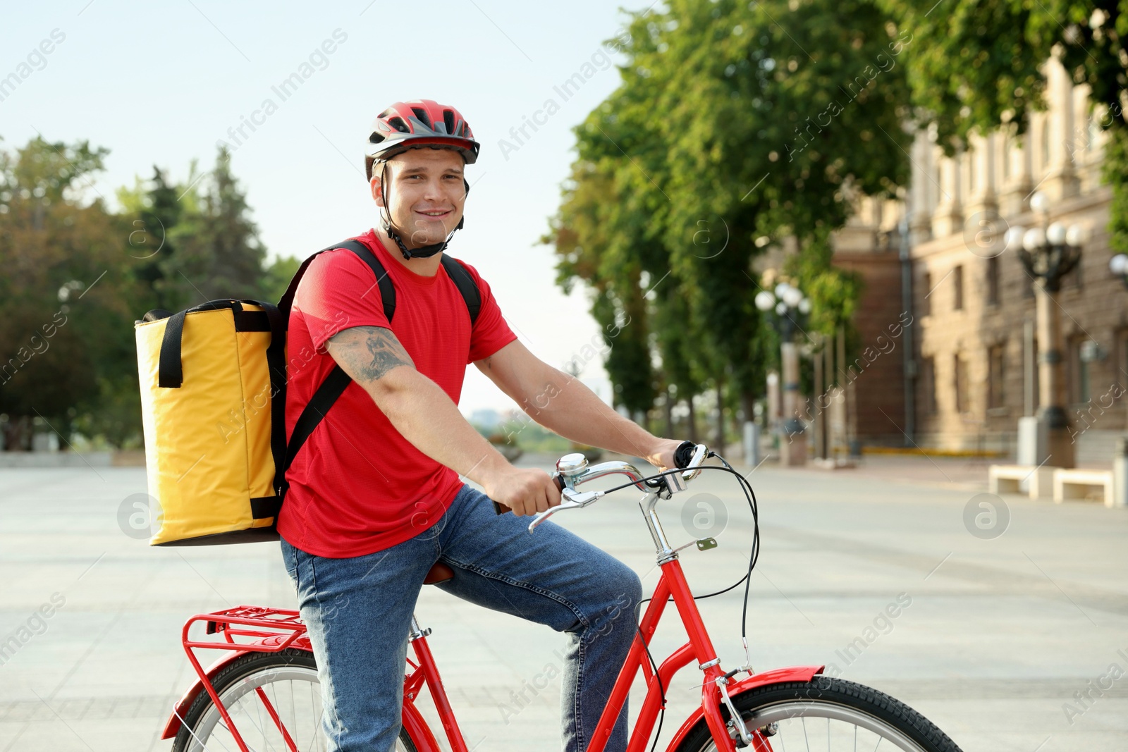 Courier with thermo bag on bicycle outdoors. Food delivery service Photo of Courier with thermo bag on bicycle outdoors. Food delivery service