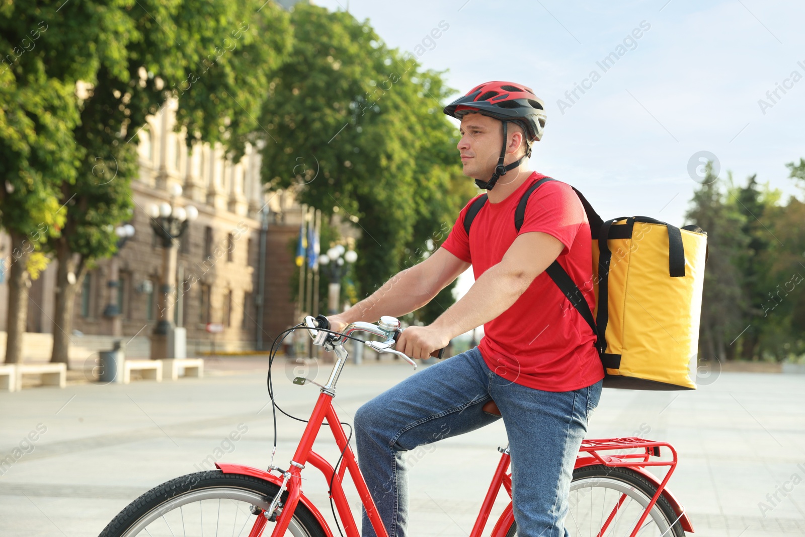 Courier with thermo bag on bicycle outdoors. Food delivery service Photo of Courier with thermo bag on bicycle outdoors. Food delivery service