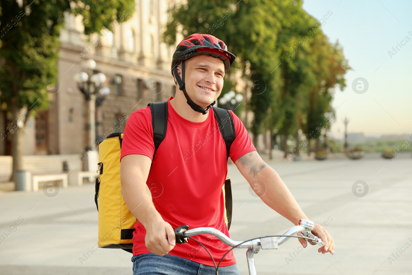 Courier with thermo bag on bicycle outdoors. Food delivery service Photo of Courier with thermo bag on bicycle outdoors. Food delivery service