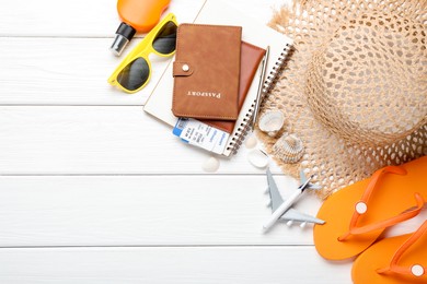 Photo of Time for summer vacation. Toy plane, passports, flight tickets, stationery and beach accessories on white wooden table, flat lay. Space for text