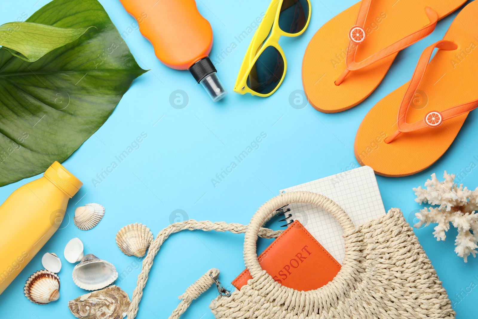 Photo of Time for summer vacation. Passport, notebook, green leaf and beach accessories on light blue background, flat lay. Space for text