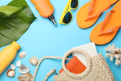 Photo of Time for summer vacation. Passport, notebook, green leaf and beach accessories on light blue background, flat lay. Space for text