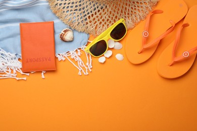 Photo of Time for summer vacation. Passport and beach accessories on orange background, flat lay. Space for text