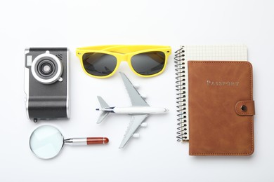 Photo of Time for summer vacation. Passport, notebook, magnifying glass, toy plane, camera and sunglasses on white background, flat lay