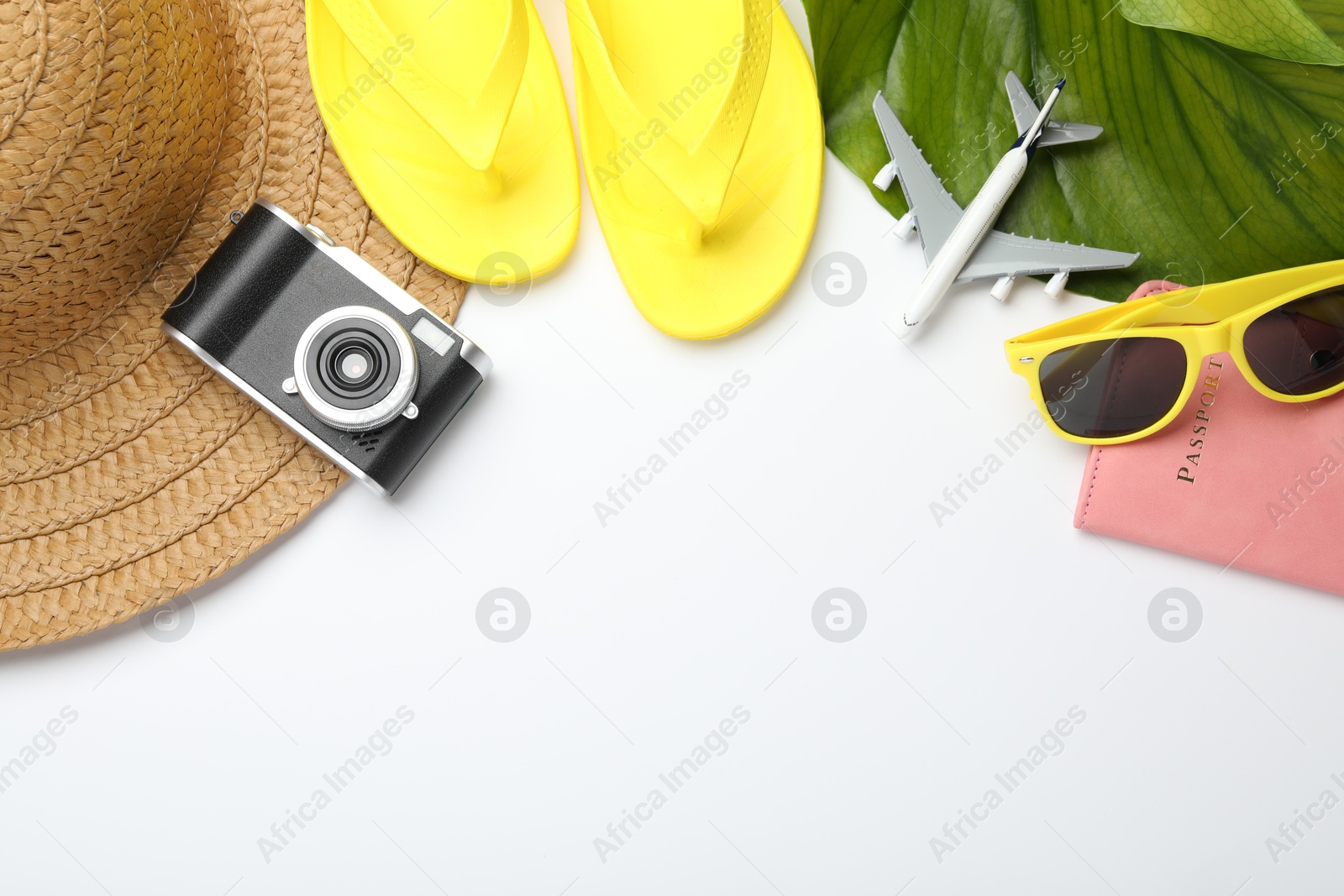 Time for summer vacation. Beach accessories, passport, toy plane, camera and green leaf on white background, flat lay. Space for text Photo of Time for summer vacation. Beach accessories, passport, toy plane, camera and green leaf on white background, flat lay. Space for text
