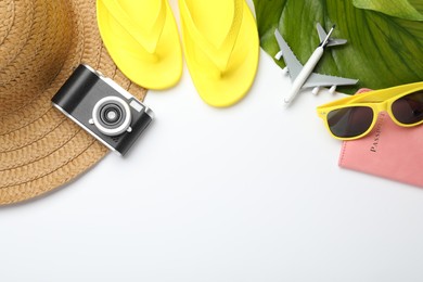 Photo of Time for summer vacation. Beach accessories, passport, toy plane, camera and green leaf on white background, flat lay. Space for text