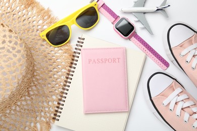 Photo of Time for summer vacation. Passport, notebook, toy plane, smart watch, shoes and beach accessories on white background, flat lay
