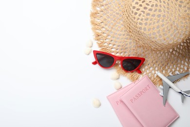 Photo of Time for summer vacation. Toy plane, passports and beach accessories on white background, flat lay. Space for text