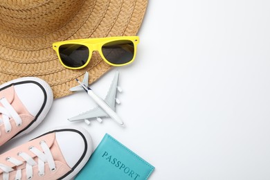 Photo of Time for summer vacation. Toy plane, passport, shoes and beach accessories on white background, flat lay. Space for text