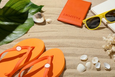 Photo of Time for summer vacation. Passport, notebook, green leaf and beach accessories on sand, closeup. Space for text