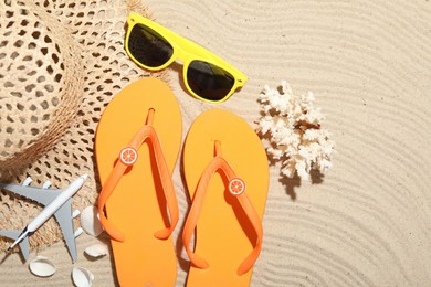 Photo of Time for summer vacation. Beach accessories and toy plane on sand, flat lay. Space for text