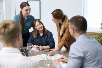 Photo of Business coach working with group of people in office