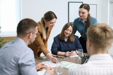 Photo of Business coach working with group of people in office