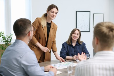 Photo of Business coach working with group of people in office