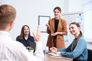 Photo of Business coach giving presentation to group of people in office