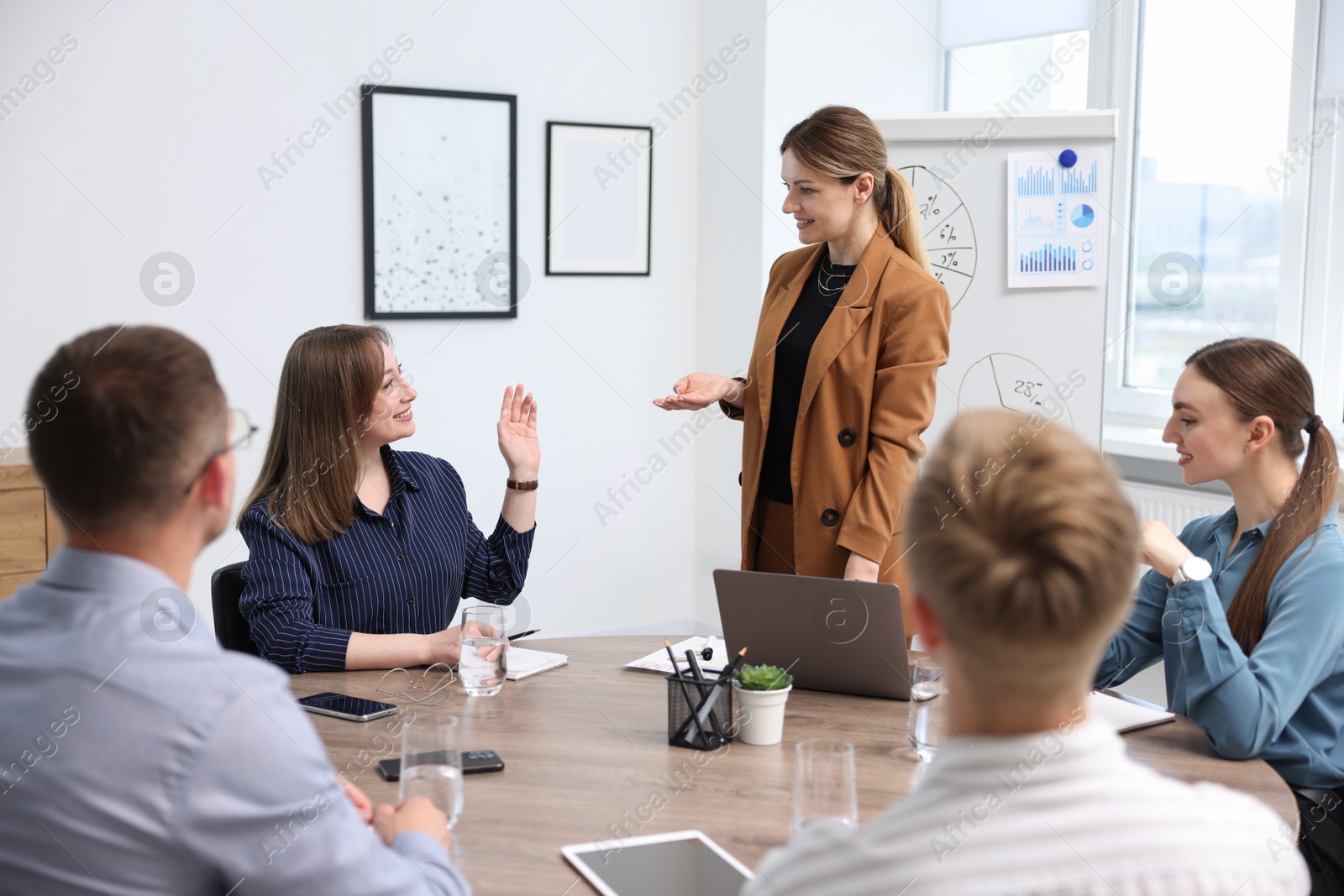 Business coach giving presentation to group of people in office Photo of Business coach giving presentation to group of people in office