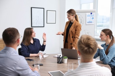 Photo of Business coach giving presentation to group of people in office