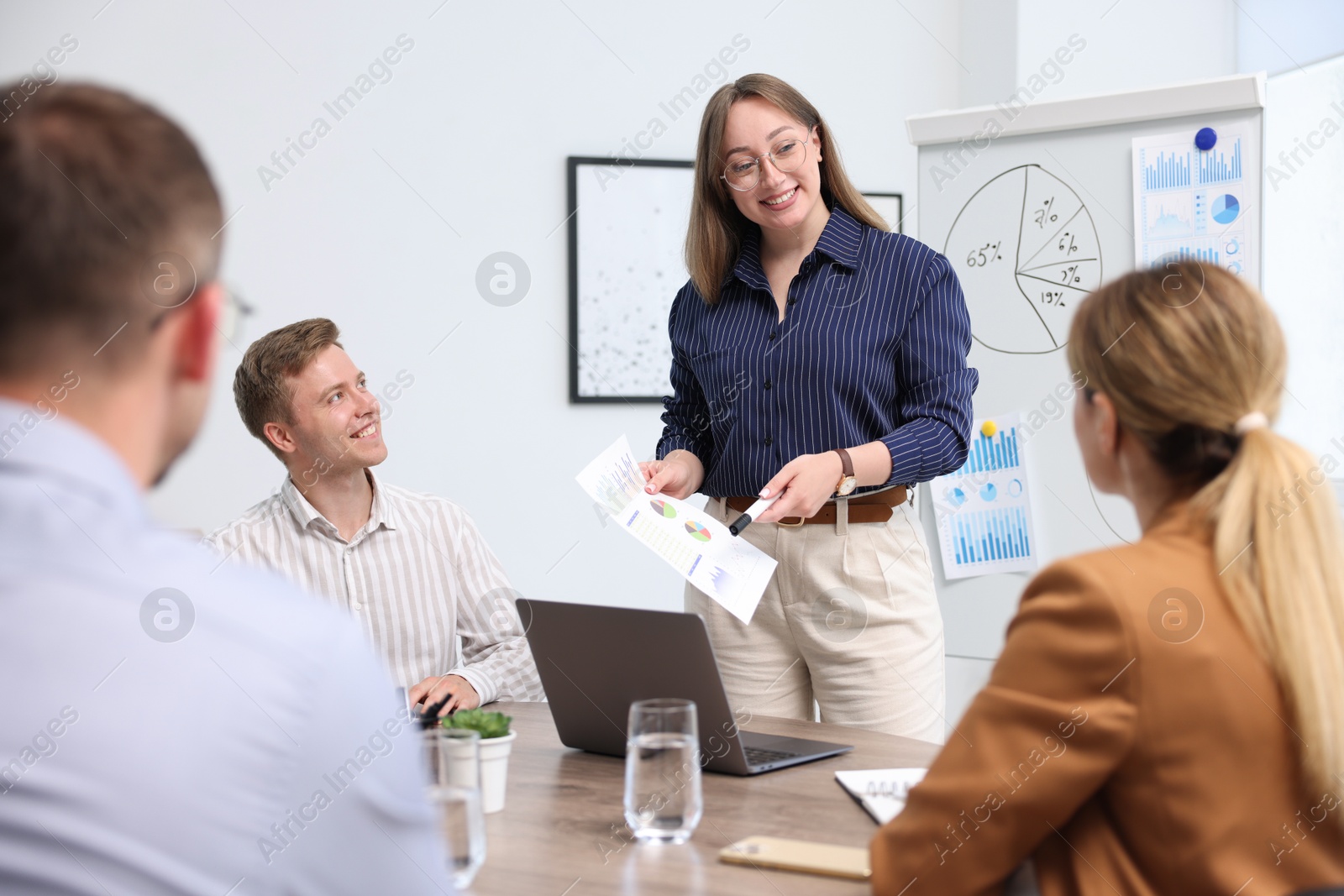 Business coach giving presentation to group of people in office Photo of Business coach giving presentation to group of people in office