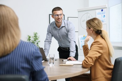 Photo of Business coach giving presentation to group of people in office