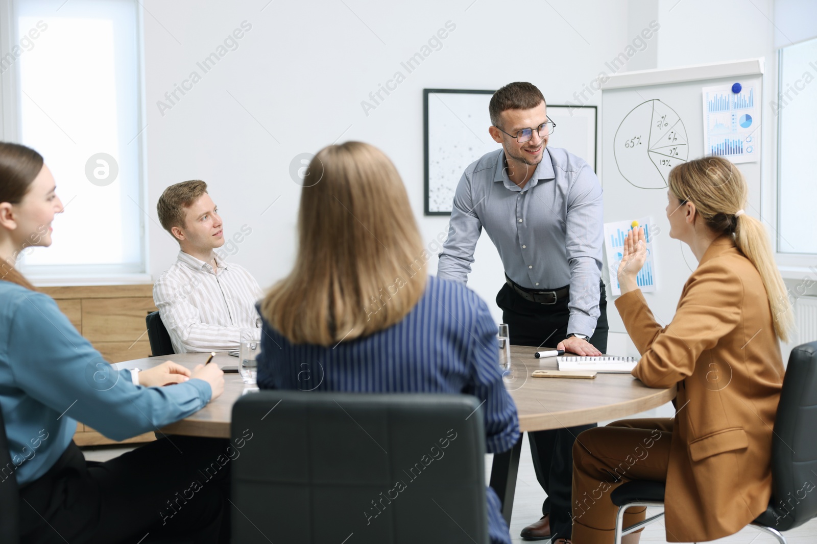 Business coach giving presentation to group of people in office Photo of Business coach giving presentation to group of people in office