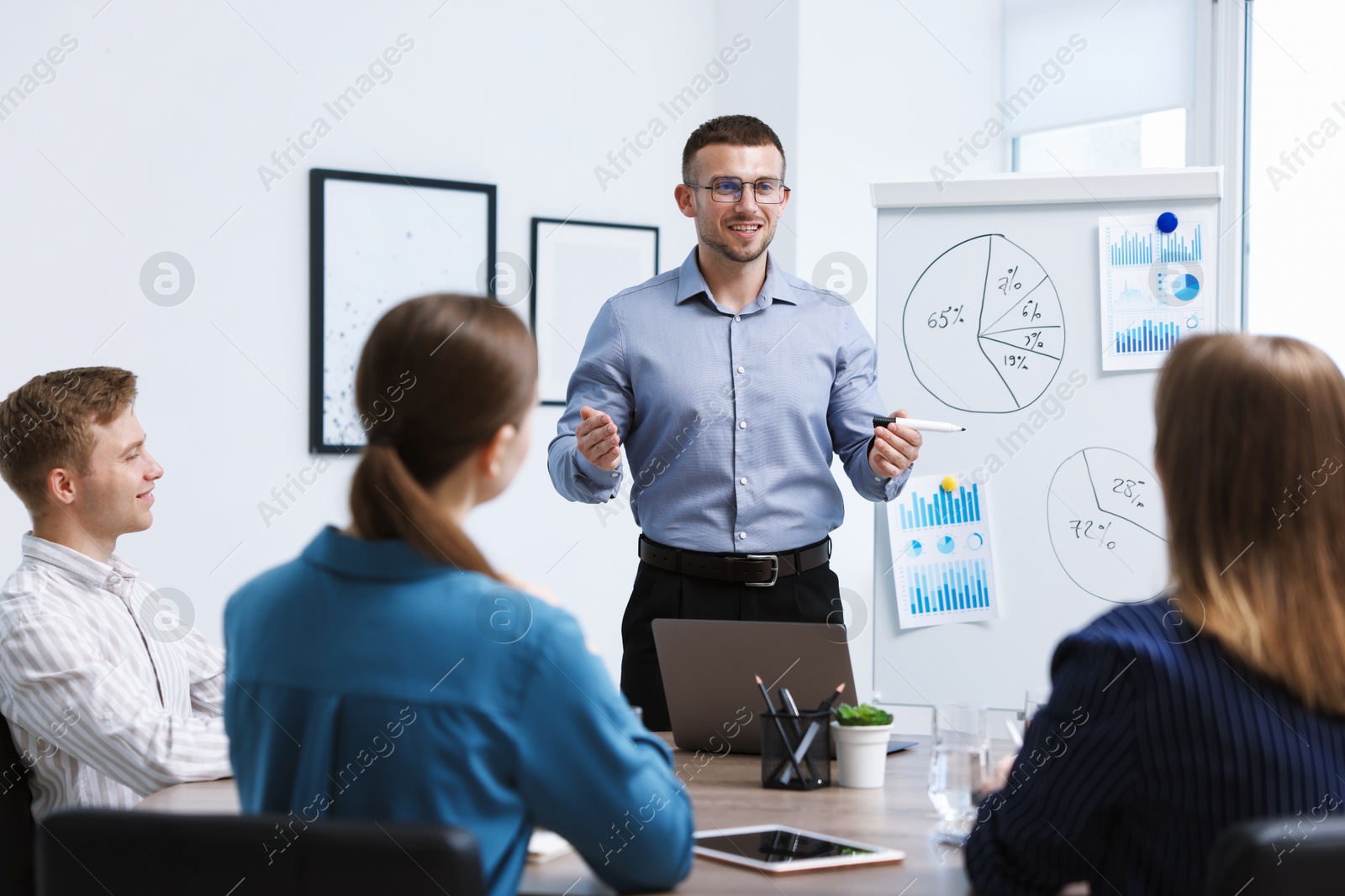 Business coach giving presentation to group of people in office Photo of Business coach giving presentation to group of people in office