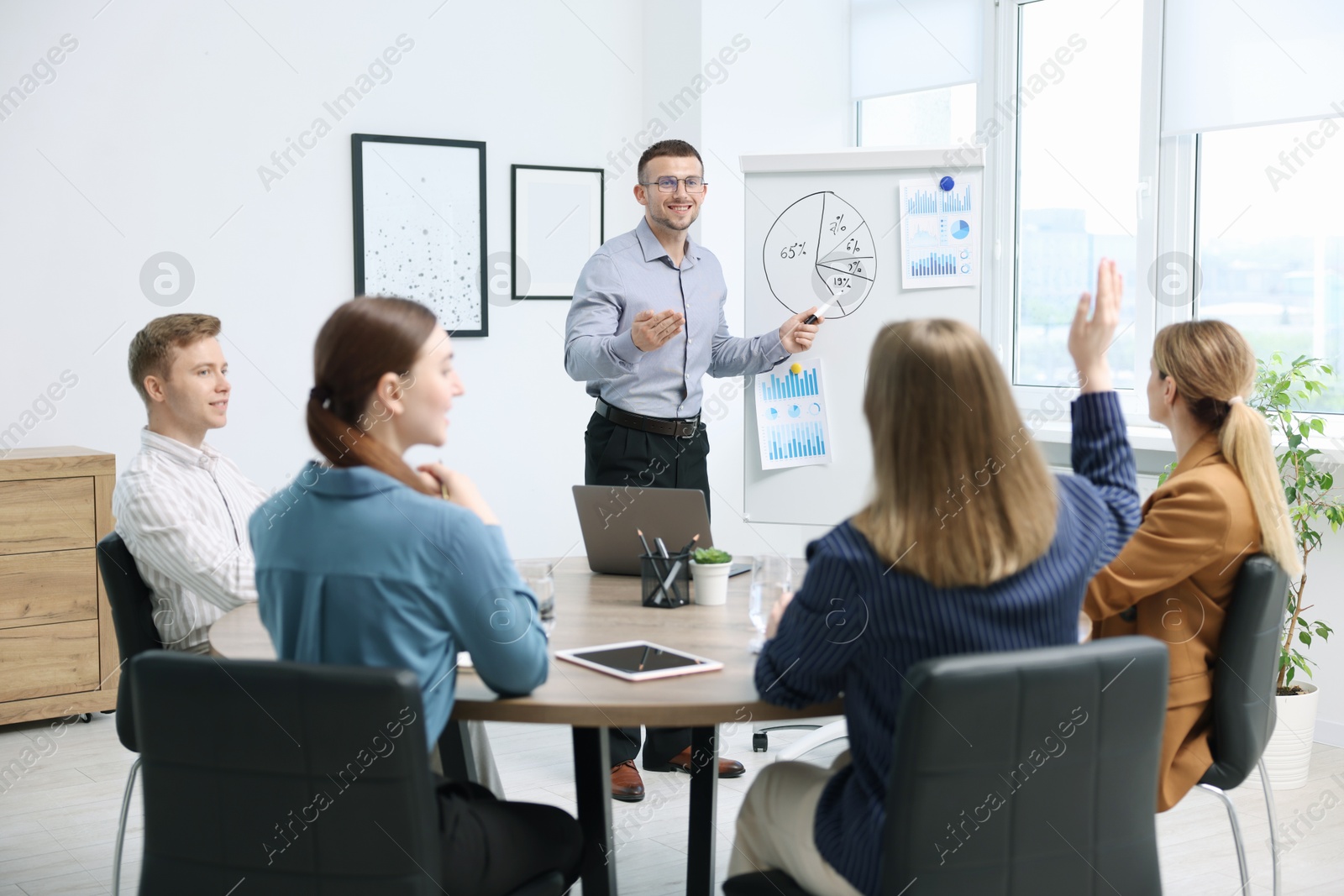Business coach giving presentation to group of people in office Photo of Business coach giving presentation to group of people in office